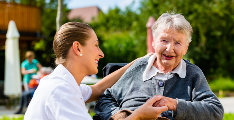 woman with dementia outside with carer